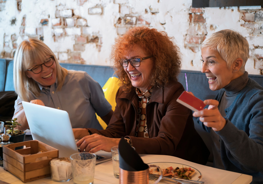 Katie Taylor founder of The Latte Lounge - 3 mature women chatting around a laptop