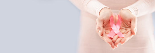 woman holding her hands out with a pink cancer ribbon in her palms 